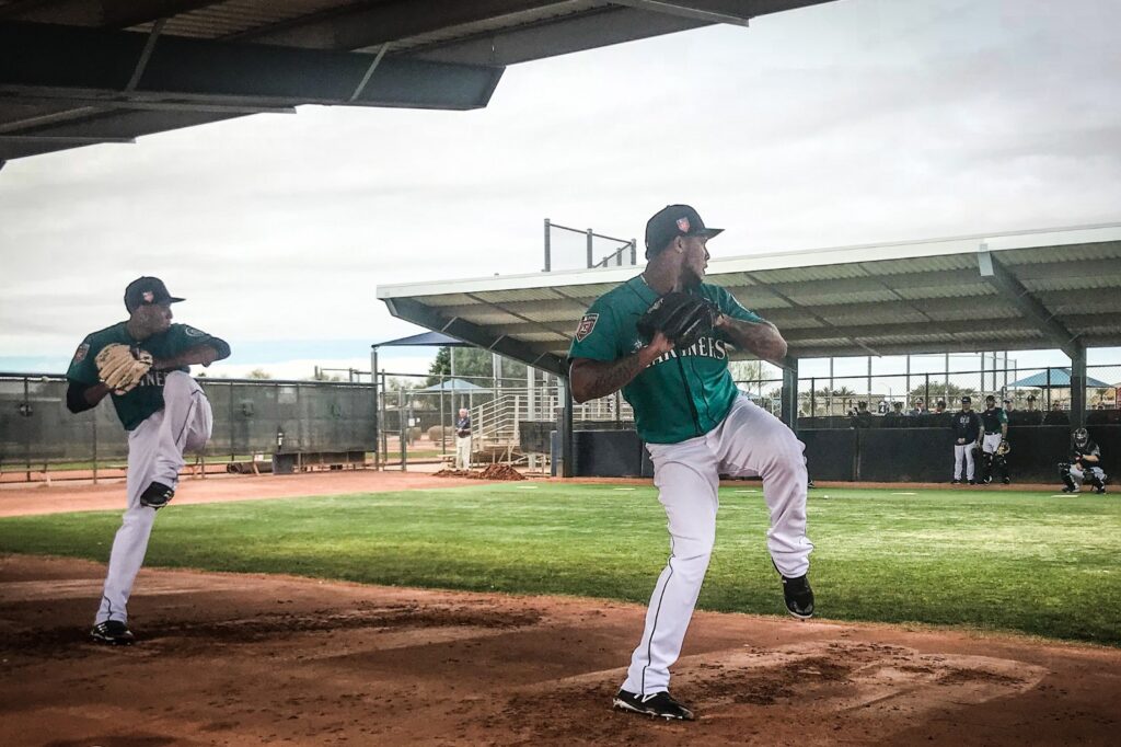 Two pitchers throwing in a bullpen.